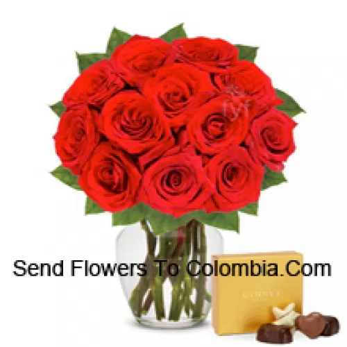 12 Red Roses With Some Ferns In A Glass Vase Accompanied With An Imported Box Of Chocolates