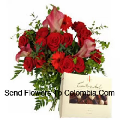 Gérberas rouges et roses dans un vase accompagnés d'une boîte de chocolats